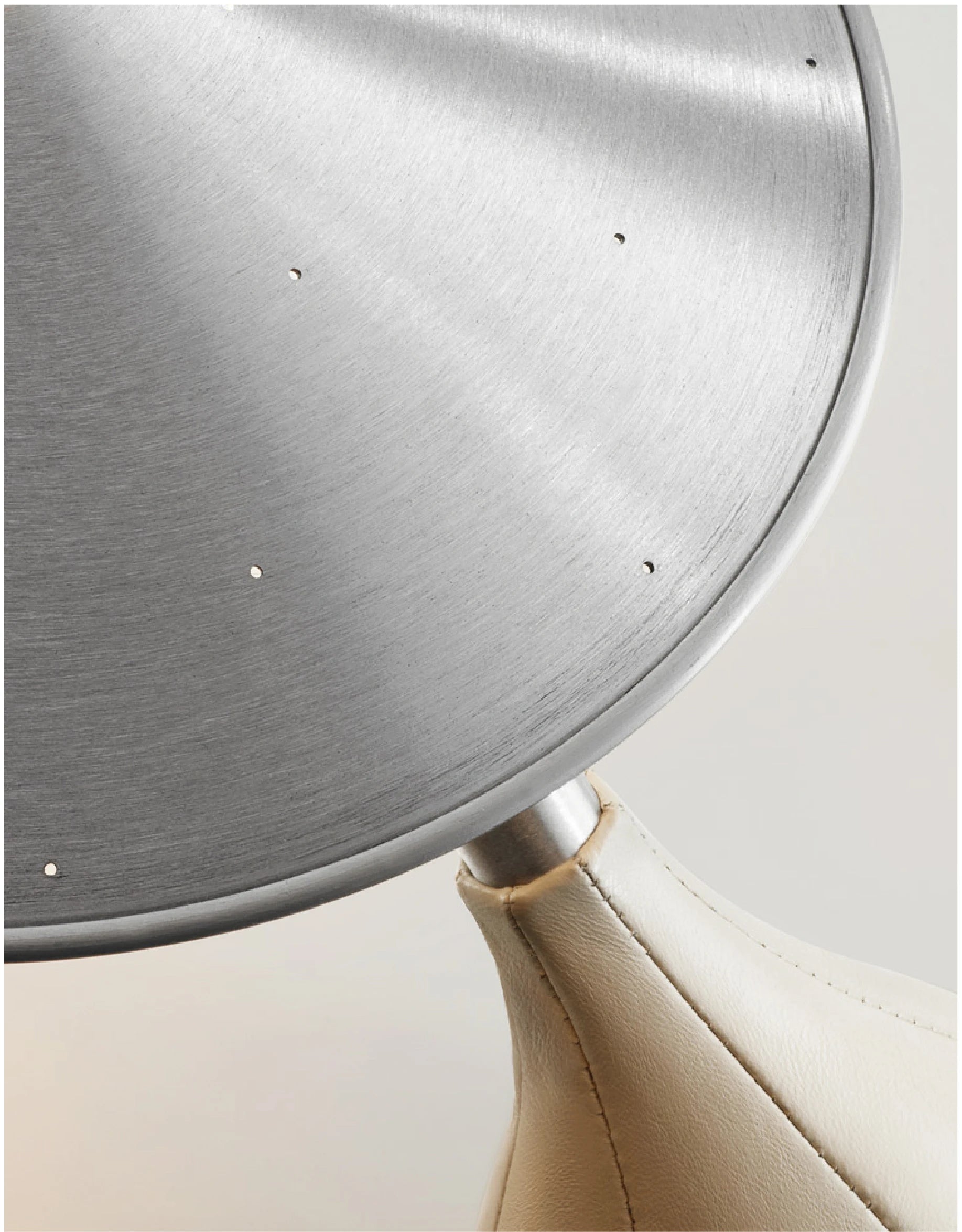 Close-up of a metallic object with a beige base on a light background