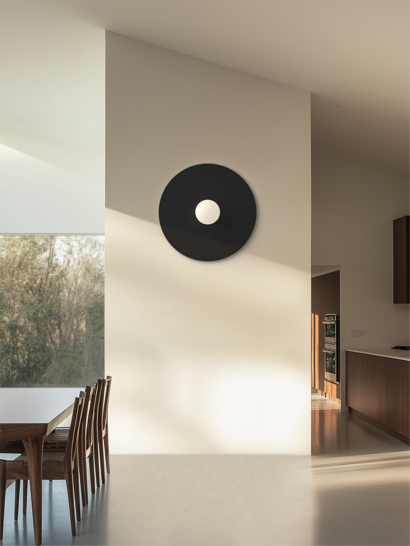 Modern interior with a black circular light fixture on a white wall.