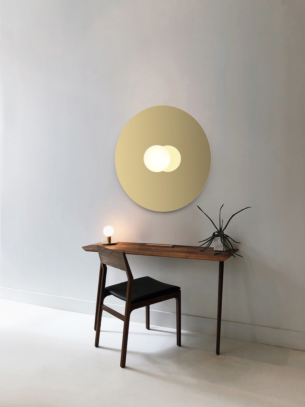 Modern interior with a round wall light fixture and wooden console table.