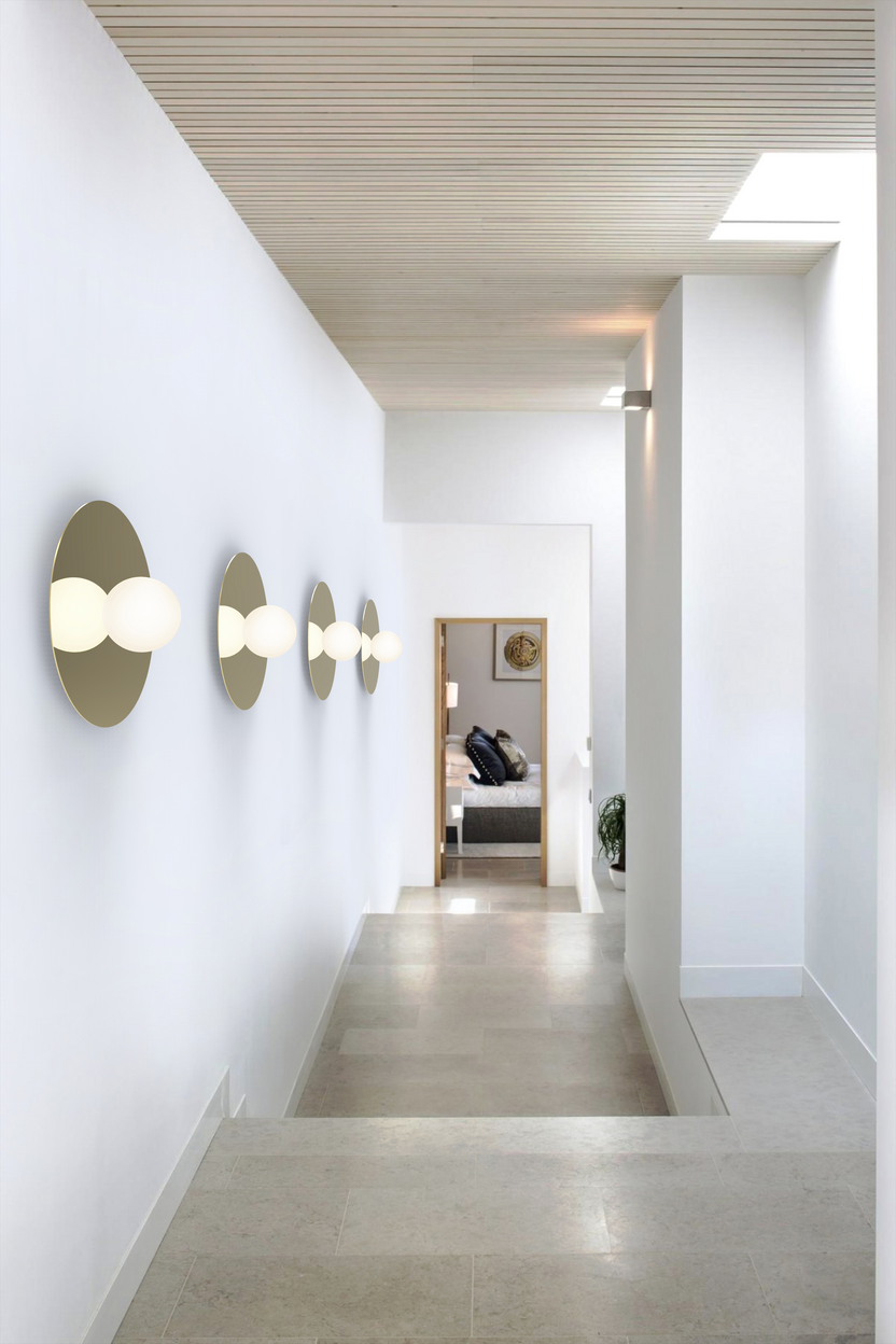 Modern hallway with wall-mounted lights and a bed in the background