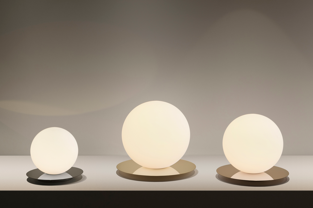 Three spherical lamps of different sizes on a neutral background