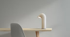White lamp on a wooden table against a gray background